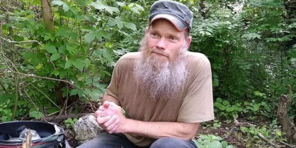 A man sitting alone in the jungle surrounded by nature and greenery