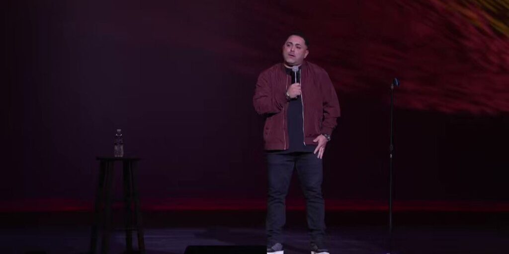 Anthony Rodia performing stand-up comedy on stage, entertaining a live audience
