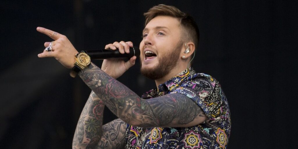 James Arthur performing live on stage in 2025, showcasing his singing talent and energetic stage presence during a concert.
