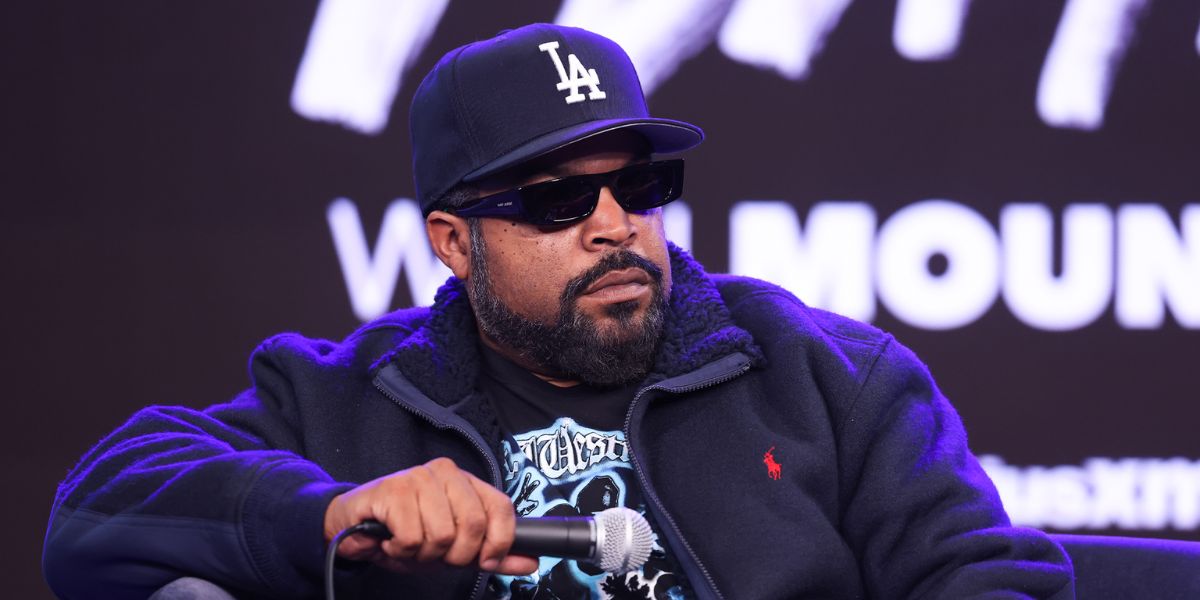 Ice Cube smiling during a media event, showcasing his successful career from rapper to Hollywood mogul